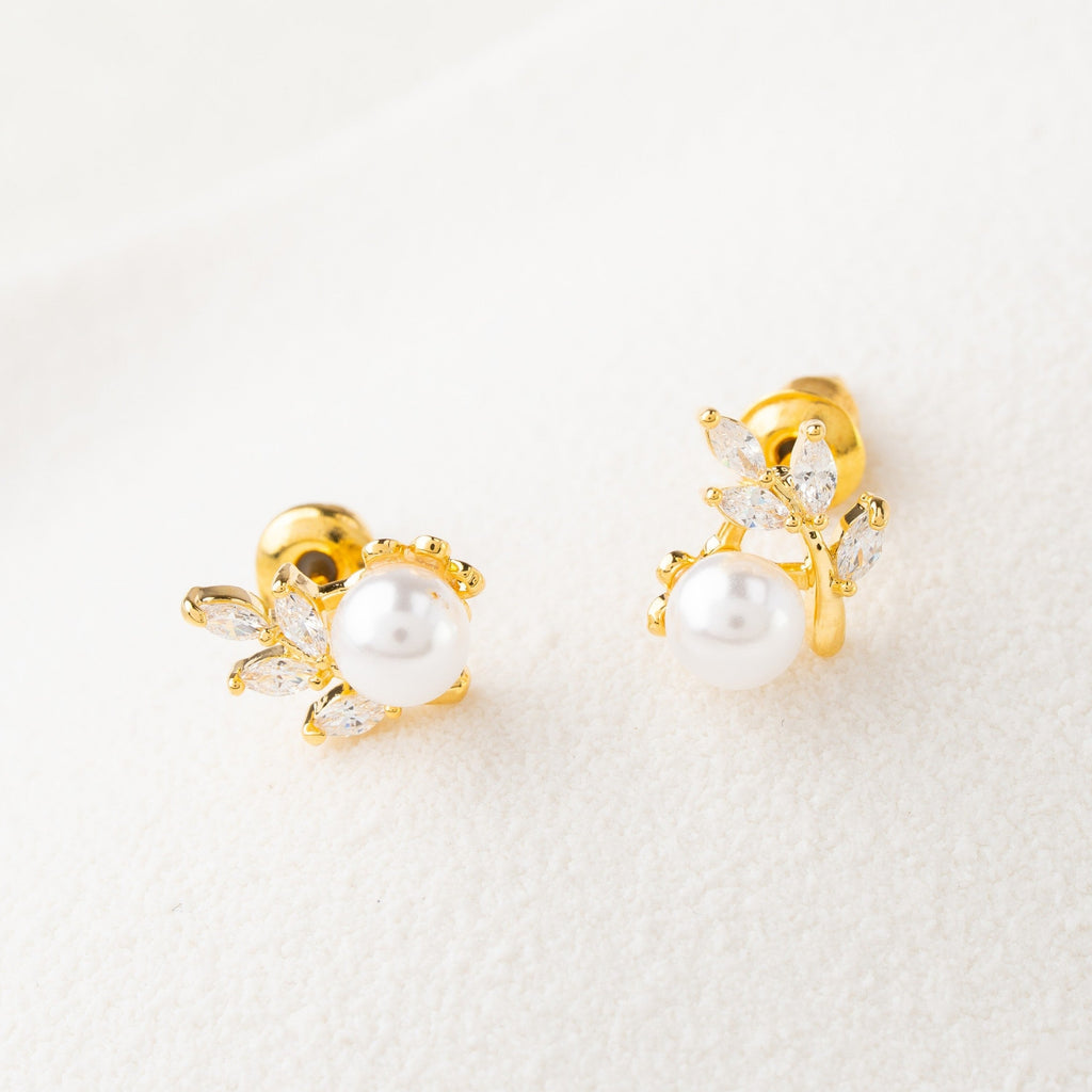 Pair of gold earrings with pearls on a white background