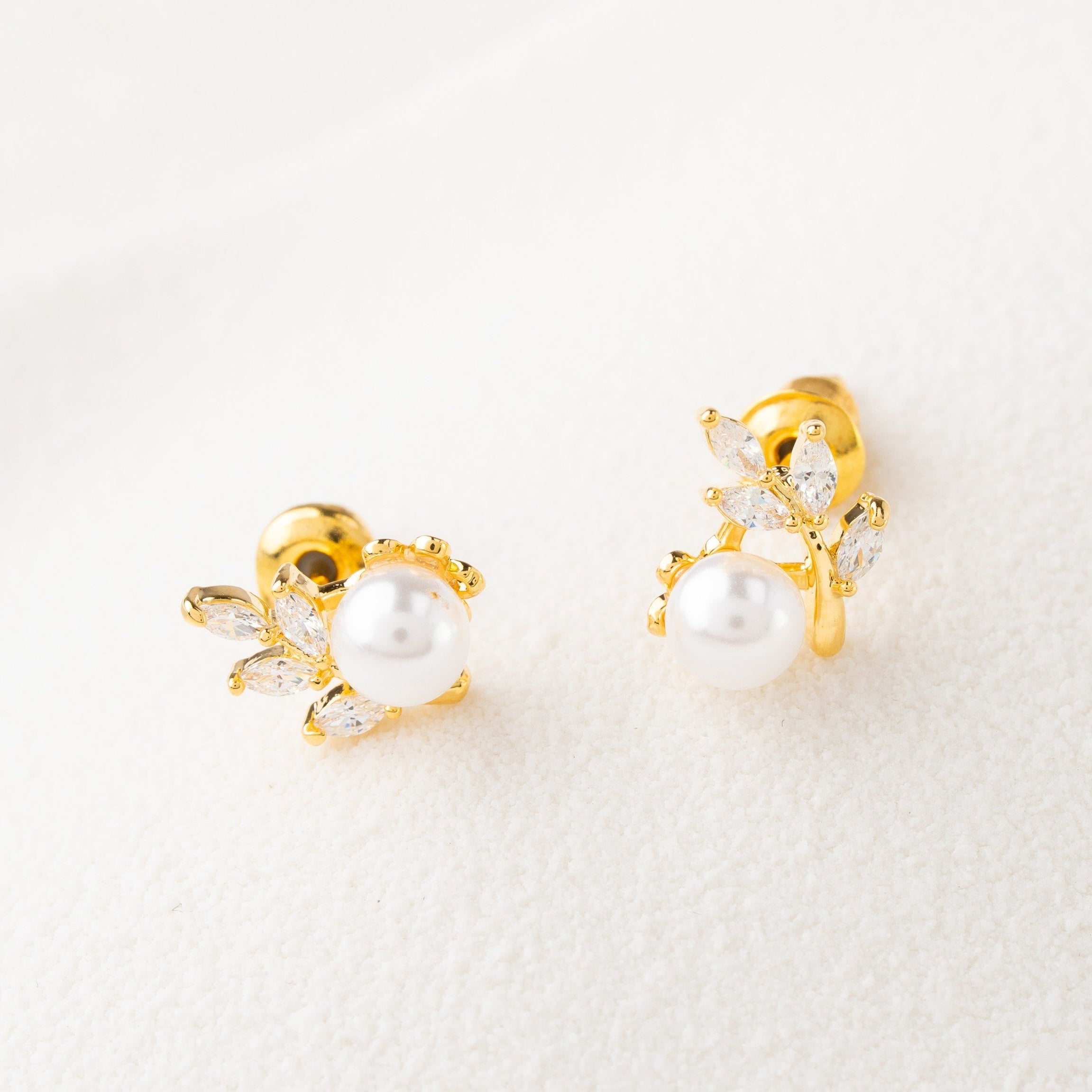 Pair of gold earrings with pearls on a white background