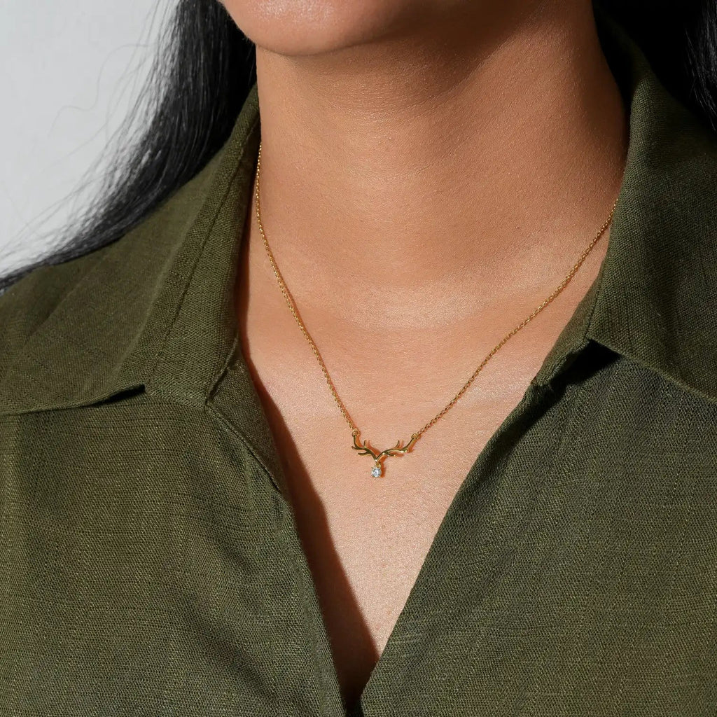Person wearing a gold necklace with a green shirt on a white background