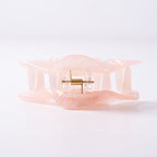 Small pink hair clip on a light background