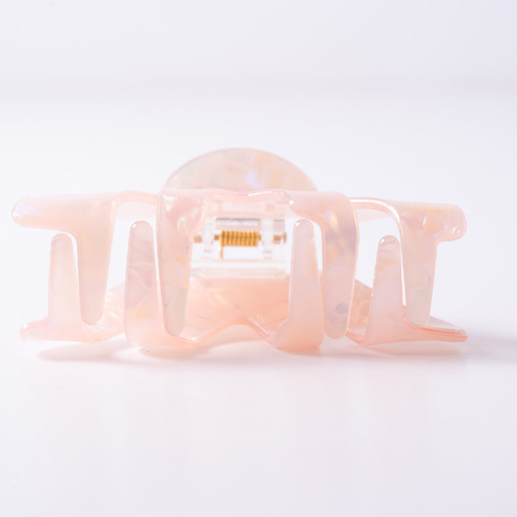 Small pink hair clip on a light background